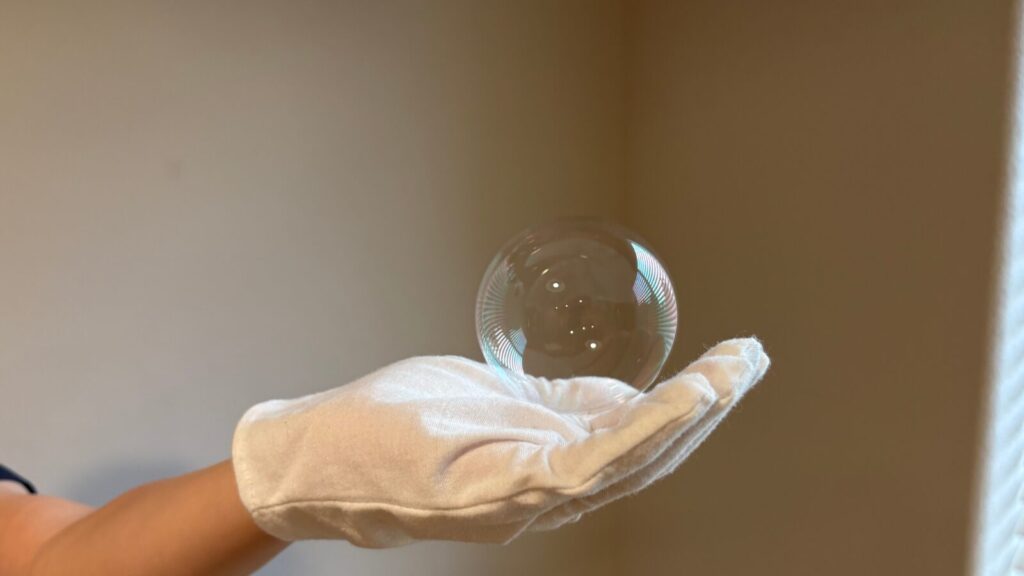 手のひらにシャボン玉が乗っている写真。